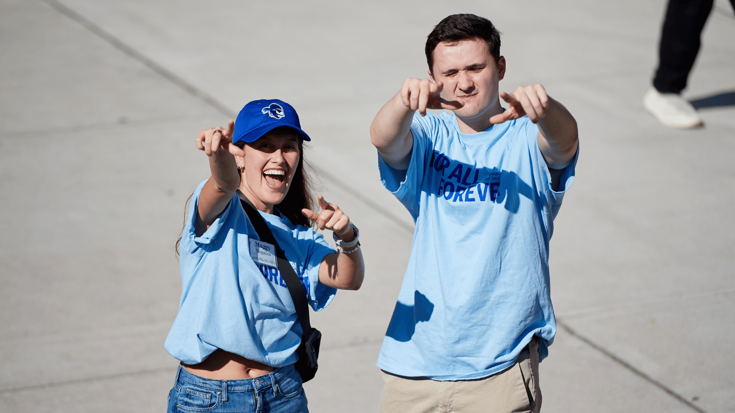 Picture of a woman and man pointing at the screen. 