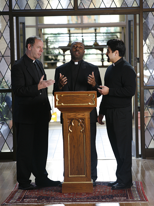 Priests and seminarians practicing giving a sermon.