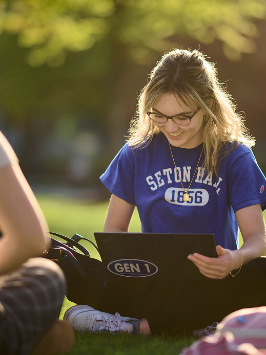 Student outdoors with laptop.