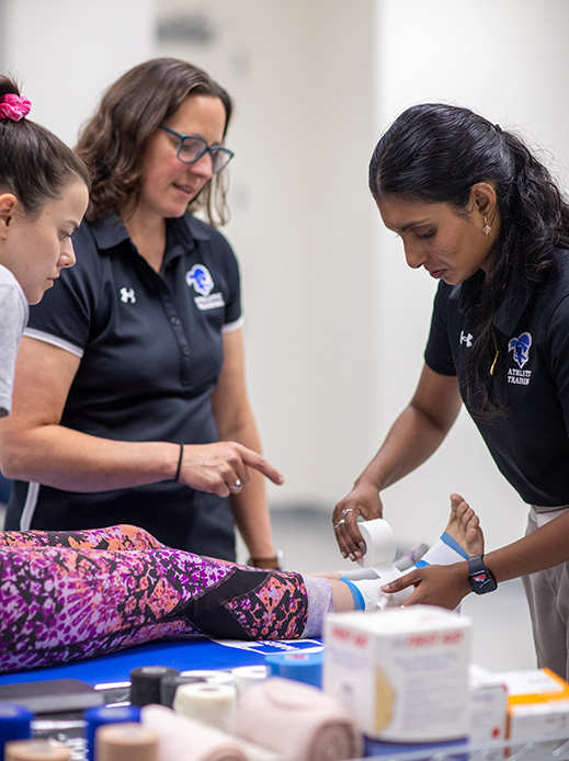 Students learning how to wrap an ankle injury.